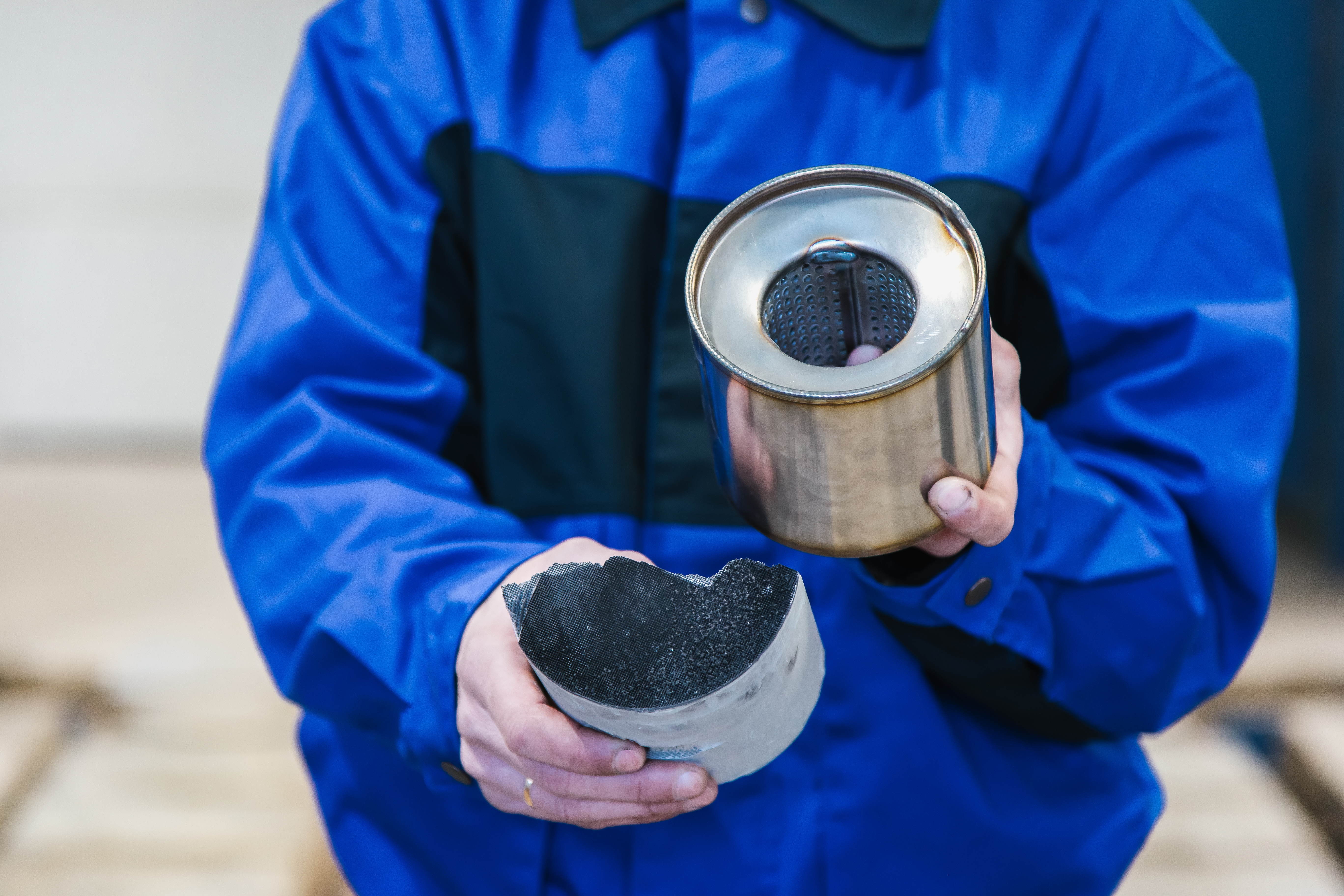 A man holding a spare car part ready to be recycled by DPF Alternatives - we provide DPF recycling!